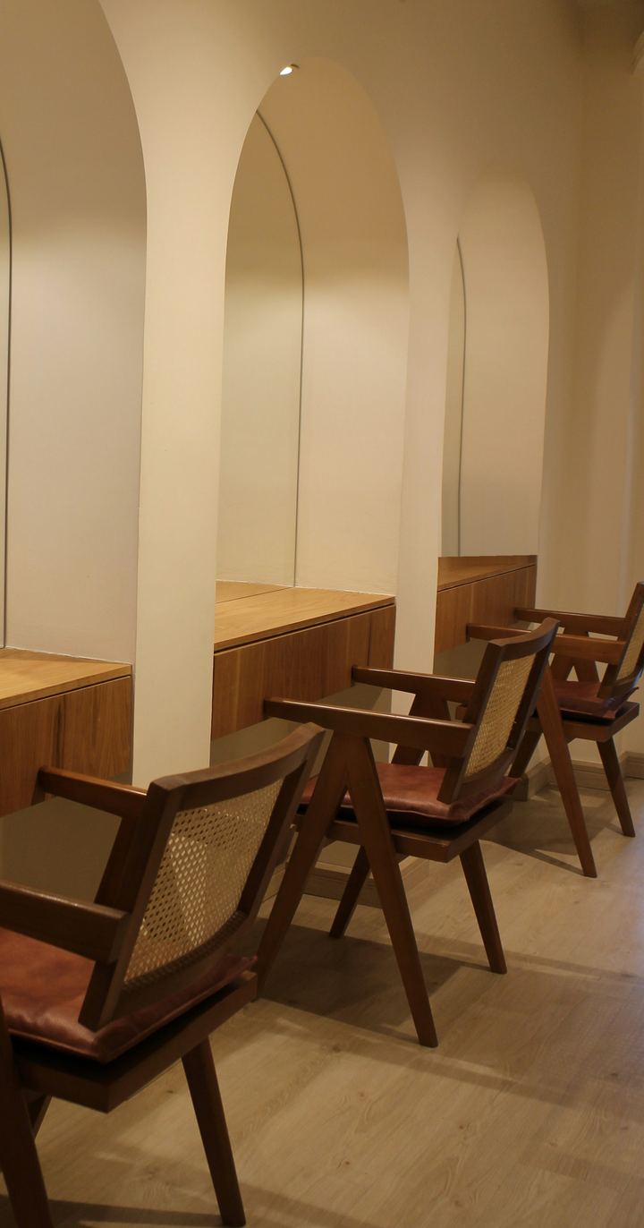 The waiting room: three wood and cane chairs along a row of arched alcoves